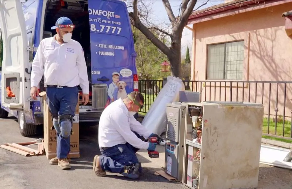 Technicians inspecting an AC Unit