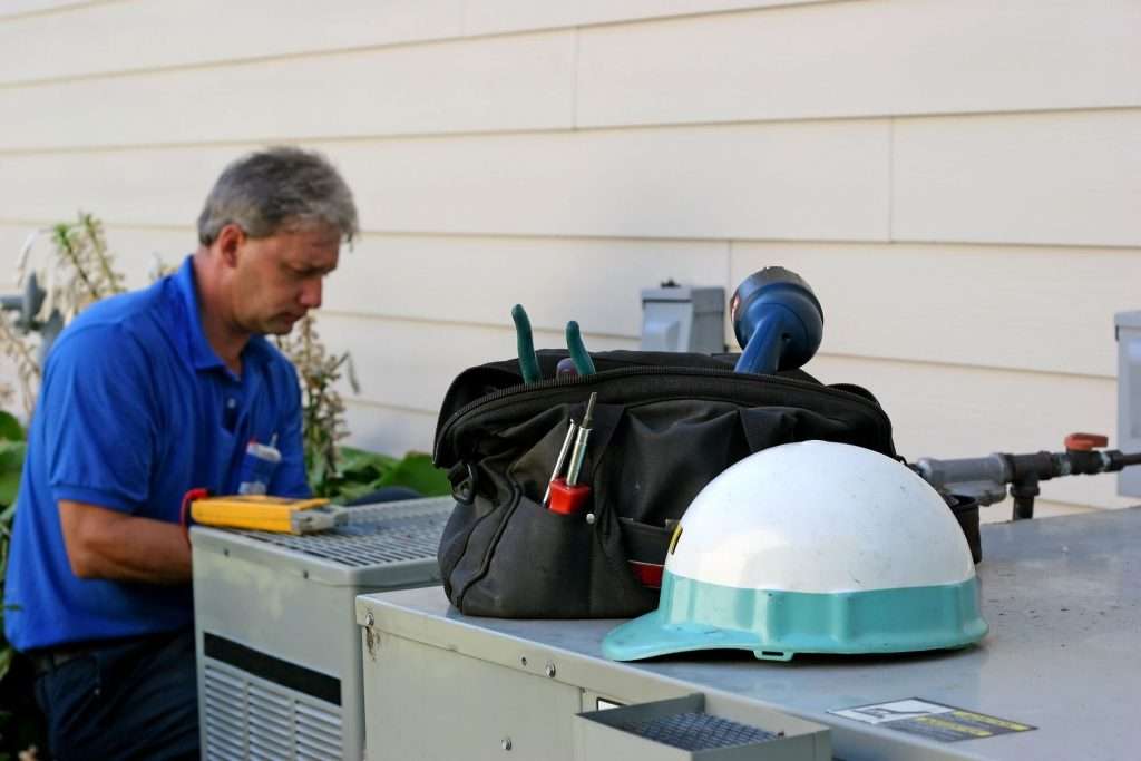 Tech repairing clogged AC