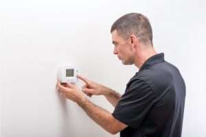 HVAC tech fixing thermostat malfunctions