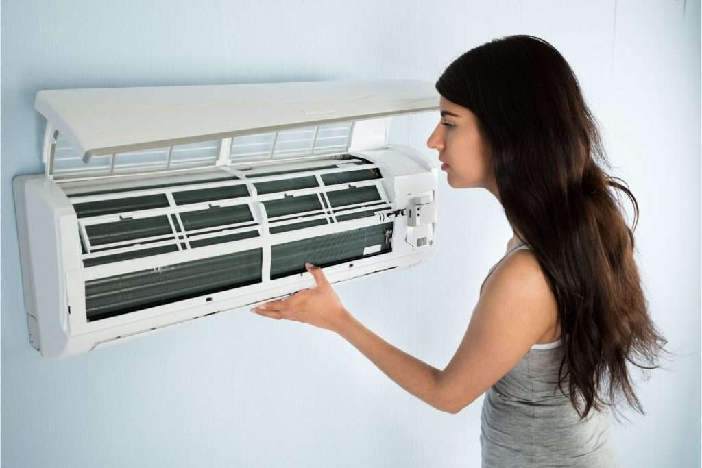 woman trying to repair an AC