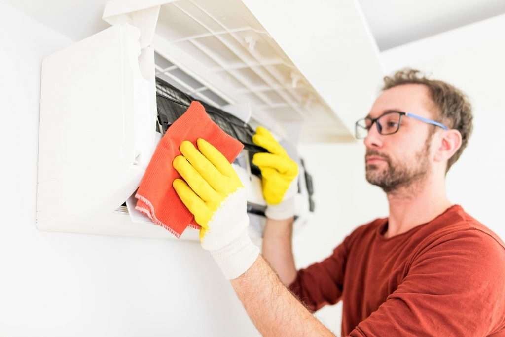 man cleaning dirty AC