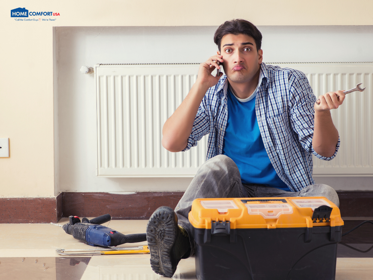 image of a man sitting on the floor holding a wrench with tools around him