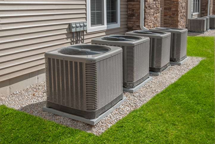 outdoor ac units sitting on rock surrounded by grass