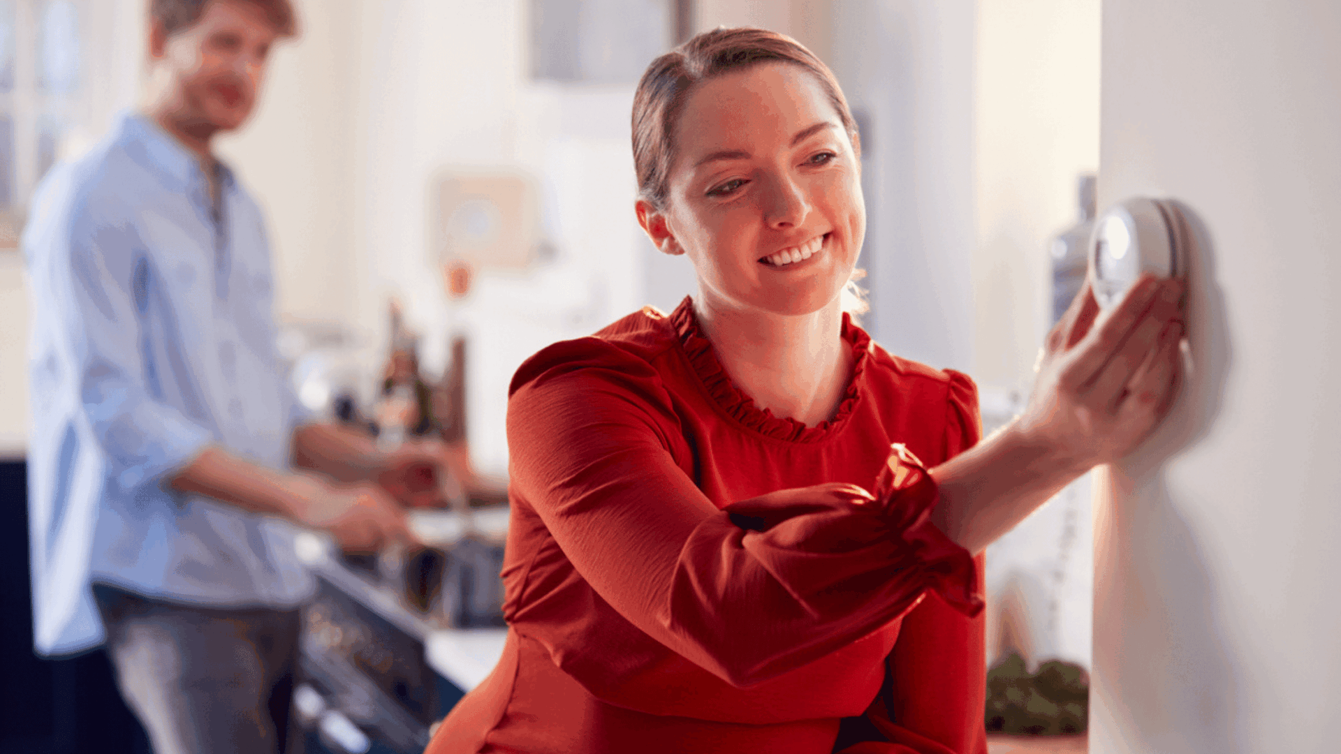 picture of a woman turning ac on and off with her husband in the background