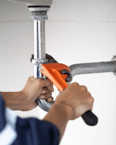 Plumber fixing pipes with wrench